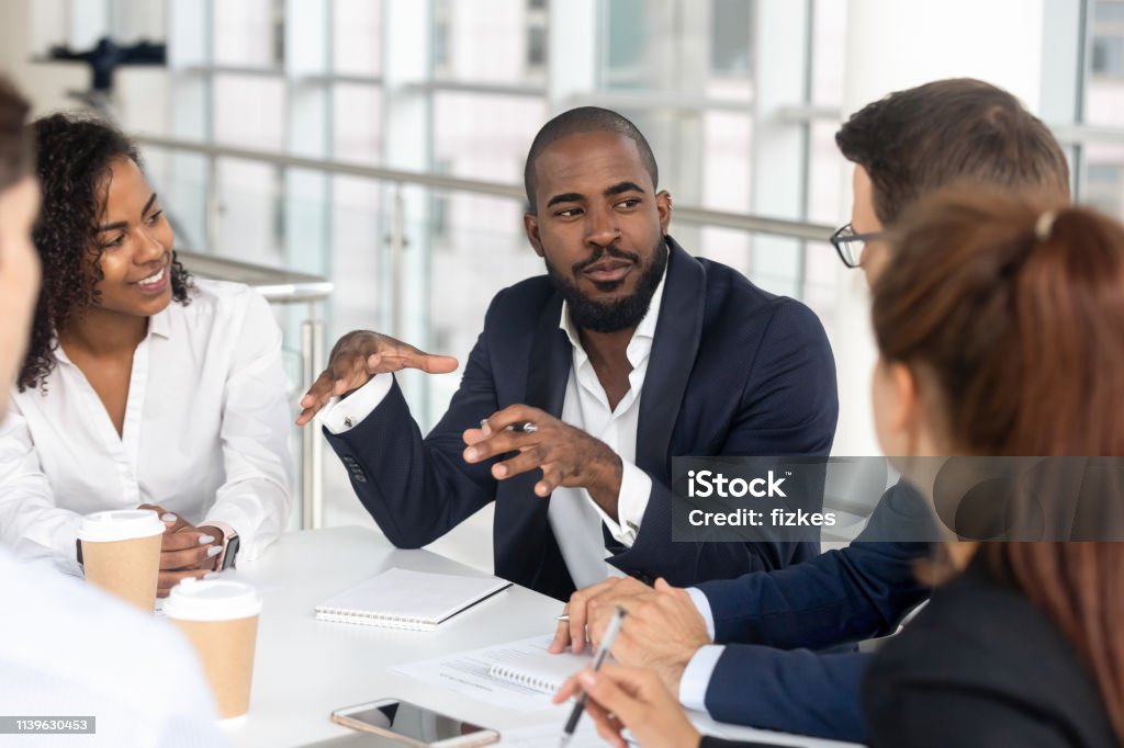 Schwarzer Millennial-Chef leitendes Firmenteam beim Briefing in der Vorstandsetage - Lizenzfrei Geschäftsleben Stock-Foto