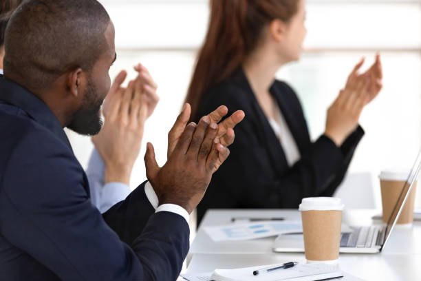istock Diverse business people applauding sitting at conference table 1139630463