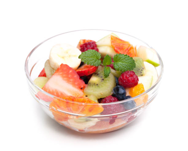 istock Fruit salad in a glass bowl isolated on white background 1139633550
