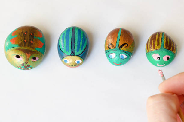 istock painted stones handmade as beetles on a white background 1139639771