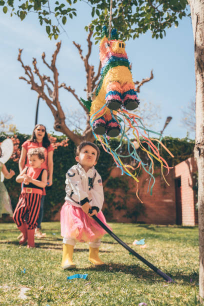 Boys breaking piñata at a party Boys breaking piñata at a party toddler hitting stock pictures, royalty-free photos & images