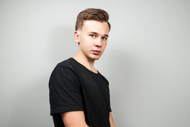 istock White young guy dressed in a black t-shirt on white background looking. 1139649373