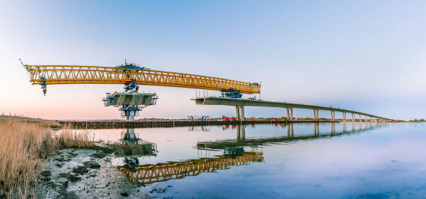 The yellow crane of the construction site at Crown Princess Mary bridge  in a panoramic view stock photo