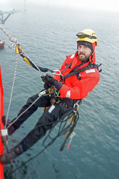 istock Manual high worker rappelling down from offshore platform in wet-suit 1139657472