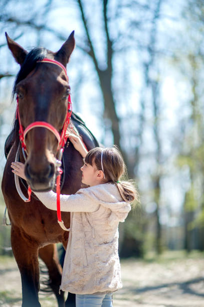 istock Young girl with horse in forest 1139659173