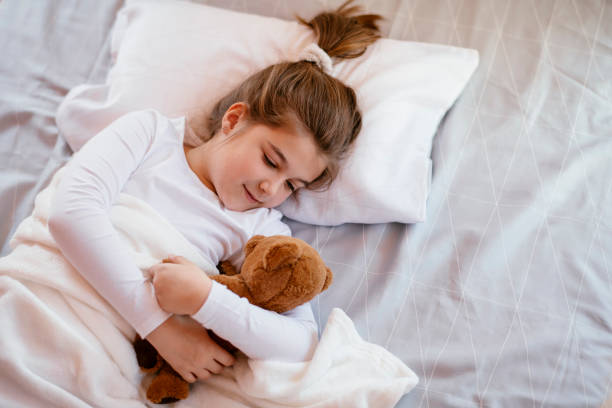 istock Little girl sleeping with teddy bear 1139661498