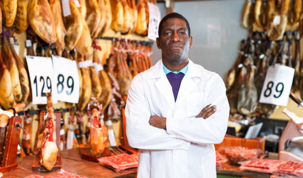 istock Butcher posing near ham counter 1139663840