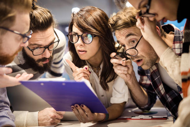 istock Team of nerdy entrepreneurs talking while reading reports in the office. 1139665466