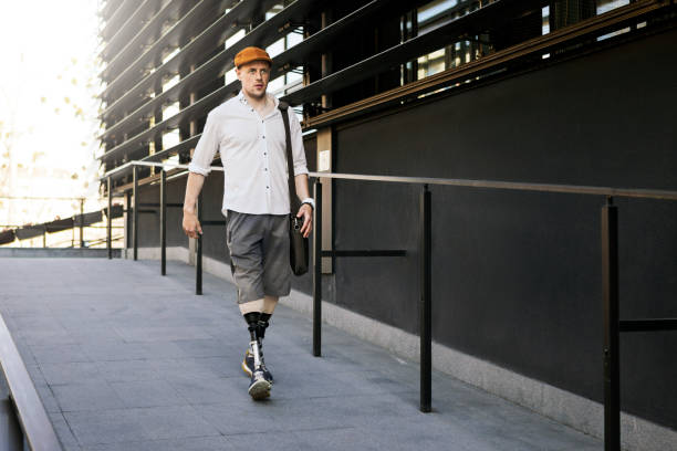 Young man with prosthetic leg in front of office building