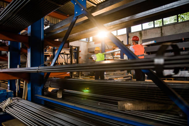 istock Two metal workers cooperating while carrying steel in a factory. 1139668909
