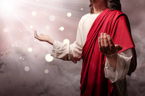istock Jesus christ raised hands and praying to god with ray 1139669720