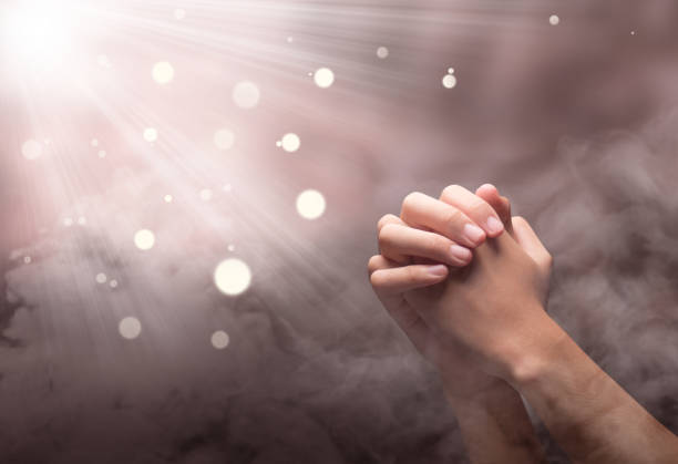 istock Male hands in praying position with ray 1139669791