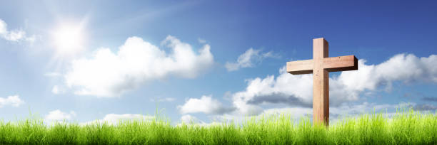istock Christian cross on the green grass with sunlight 1139670894