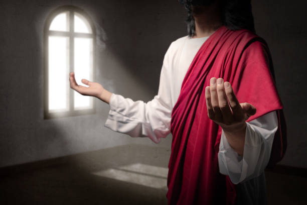 istock Jesus christ raised hands with open palms and praying to god inside the room 1139671004