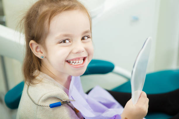 istock Little child looks at snowy white teeth in mirror 1139671343
