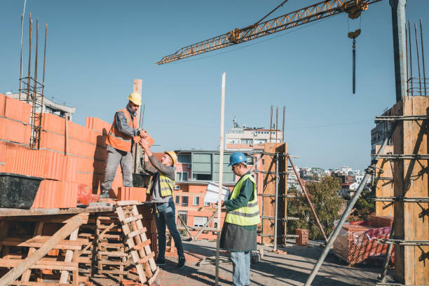 istock Construction Workers are Building a Brick Wall at the Rooftop of the Building 1139673307