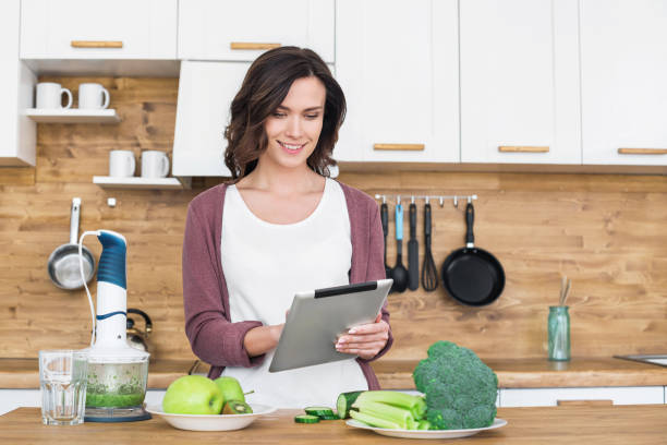 istock Woman preparing food following recipe using digital tablet 1139673330