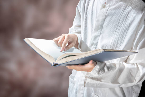 istock Muslim man standing while reading the quran on his hands 1139677451