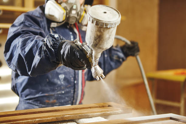 Staining wood with white spray gun. Application of flame retardant ensuring fire protection, airless spraying device. Staining wood with white spray gun, close-up shot. Application of flame retardant ensuring fire protection, airless spraying. airless stock pictures, royalty-free photos & images