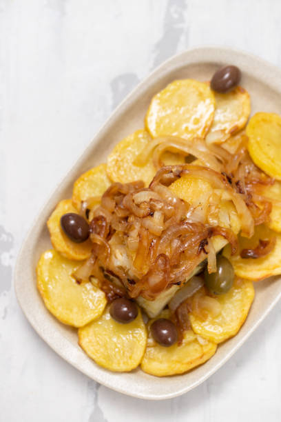 istock baked cod fish with potato, onion and olives 1139678976