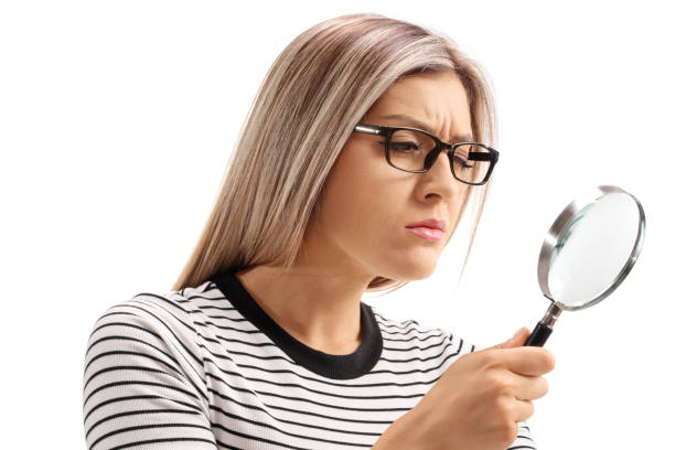 istock Young woman looking through a magnifying glass 1139680221