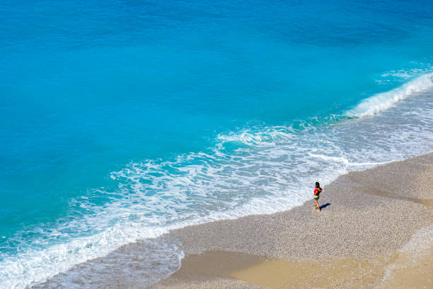 Summer scenery at the beach with turquoise  sea horizon of dramatic clouds, rocks, rainy weather and sunny day