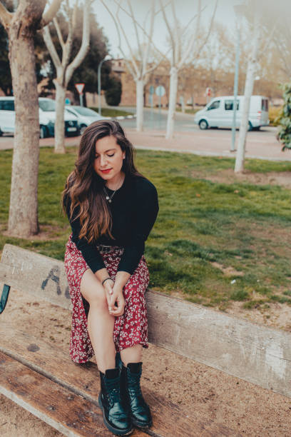 istock Thoughtful young woman sitting on a bench 1139684220