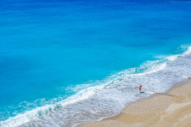 istock Happy woman walking on the beach. 1139684514