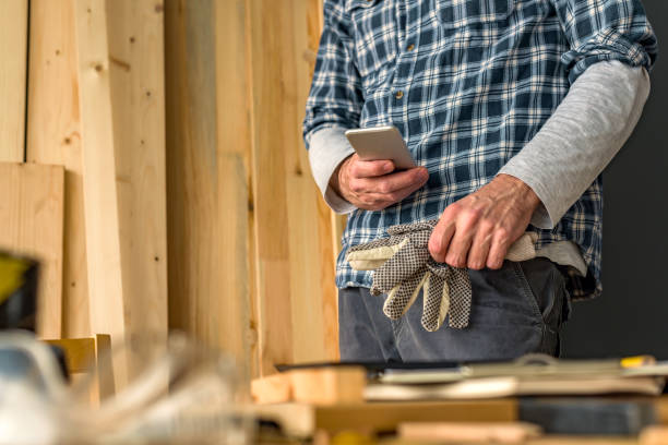 istock Carpenter using smartphone in small business woodwork workshop 1139684667