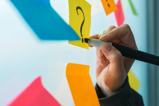 istock Businesswoman writing question marks on colorful sticky note paper 1139684714
