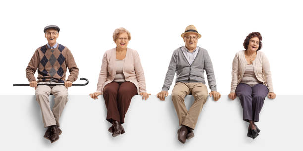 istock Two senior men and two senior women sitting on a white panel and posing 1139685843