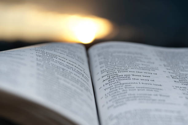 istock Open Bible with beautiful sunset to the background. 1139690006