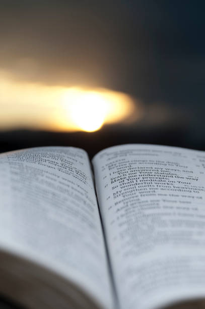 istock Open Bible with stunning sunset in the background. 1139690015