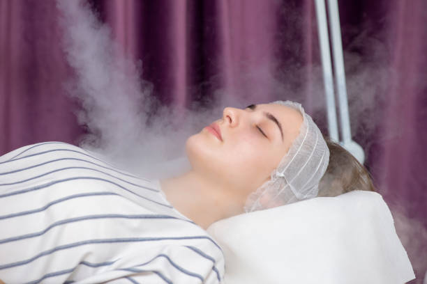 Beauty treatment of young female face, ozone facial steamer stock photo