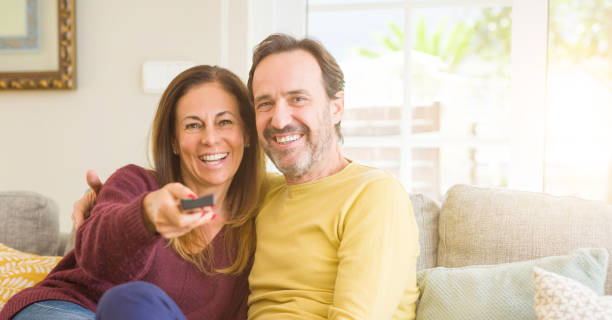 istock Romantic middle age couple watching tv on the sofa at home 1139693103