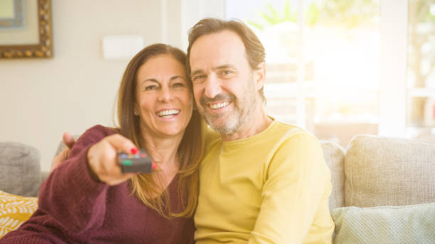 istock Romantic middle age couple watching tv on the sofa at home 1139693168