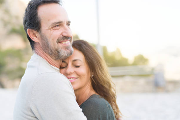 istock Romantic couple smiling,  cuddling and hugging on a sunny day 1139693590