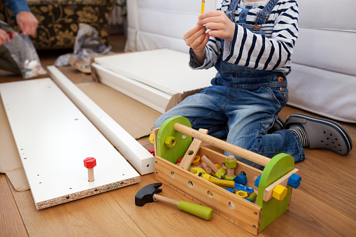 Child playing with toy toolbox at home