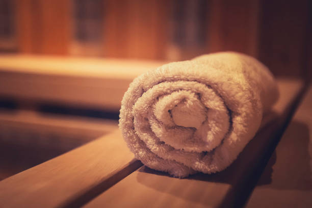 A close up of a soft terry bath towel in a wooden steam sauna. Comfortable rest in a traditional Russian cedar bath. Execellent conviniences for relaxation in steam room of eco-designed sauna. A close up of a soft terry bath towel in a wooden steam sauna. Comfortable rest in a traditional Russian cedar bath. Execellent conviniences for relaxation in steam room of eco-designed sauna sauna stock pictures, royalty-free photos & images