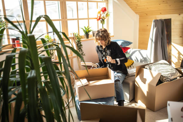 istock Woman Unpacking boxes at her new home 1139701890