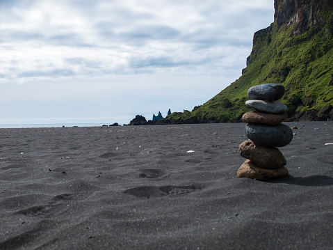 Stack of pebble stones at the black sand beach in the south of Iceland.