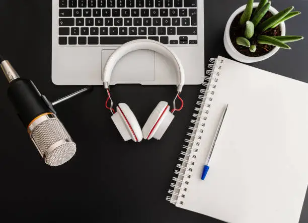 Photo of podcast recording concept with audio recording equipment on dark table