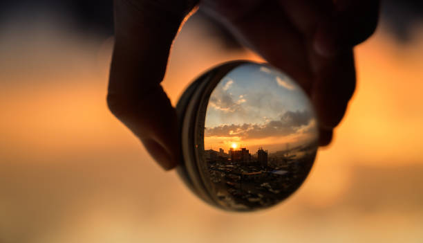 istock Glass ball which reflects sunset sky over city. 1139713219