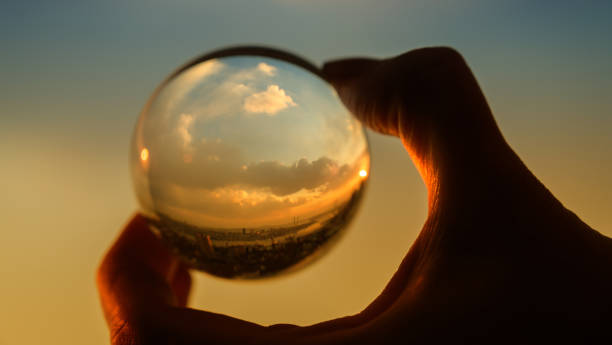 istock Glass ball which reflects sunset sky over city. 1139713245