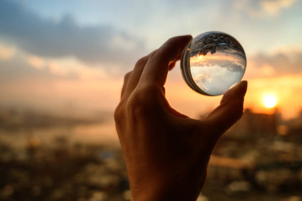 istock Glass ball which reflects sunset sky over city. 1139713261