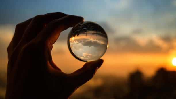 istock Glass ball which reflects sunset sky over city. 1139713277