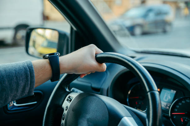 istock man driving car by city streets 1139713661