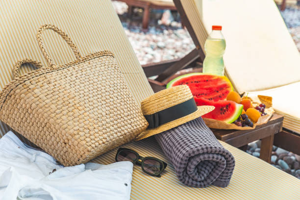 spiaggia roba borsa asciugamano coperta su sole più a lungo. frutti sul tavolo. vacanze estive - beach table peach fruit foto e immagini stock