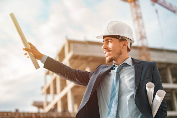 young male civil engineer or businessman makes shadow by lifting his hand into the air - corporate business manager manual worker architect imagens e fotografias de stock