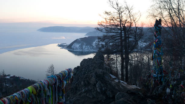 Ribbons for good luck tied on the observation platform of the Chersky stone in Listvyanka. View of Angara river and Baikal. Sunset in Siberia stock photo